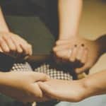 unanswered prayers - People sitting in a prayer circle with hands joined in prayer