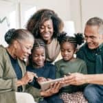 grandparents with their grandchildren and daughter looking at something - Bible verses for grandma and grandpa at hope filled faith