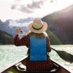 3 ways to find rest in Christ - woman paddling out on the water towards mountains - hope filled faith