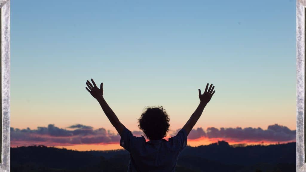 Thanksgiving Bible verses KJV Hope Filled Faith - picture of a woman with her arms outstretched in praise against a sunset sky