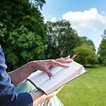 3 - beginner Bible reading plans - woman reading in a park