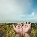3 - person's hands held open against a field background - finding strength in God